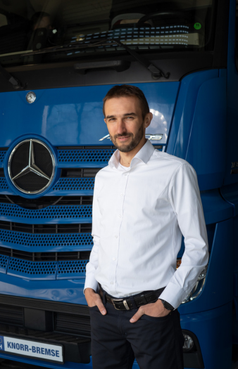 A man standing in front of a Knorr-Bremse truck