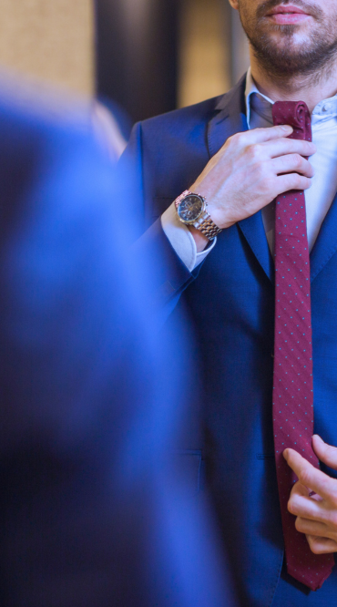 A man standing in a suit preparing for his job interview